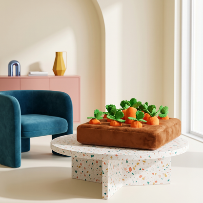 Plush brown snuffle mat dog toy shaped like a garden bed with removable orange carrots and green tops.