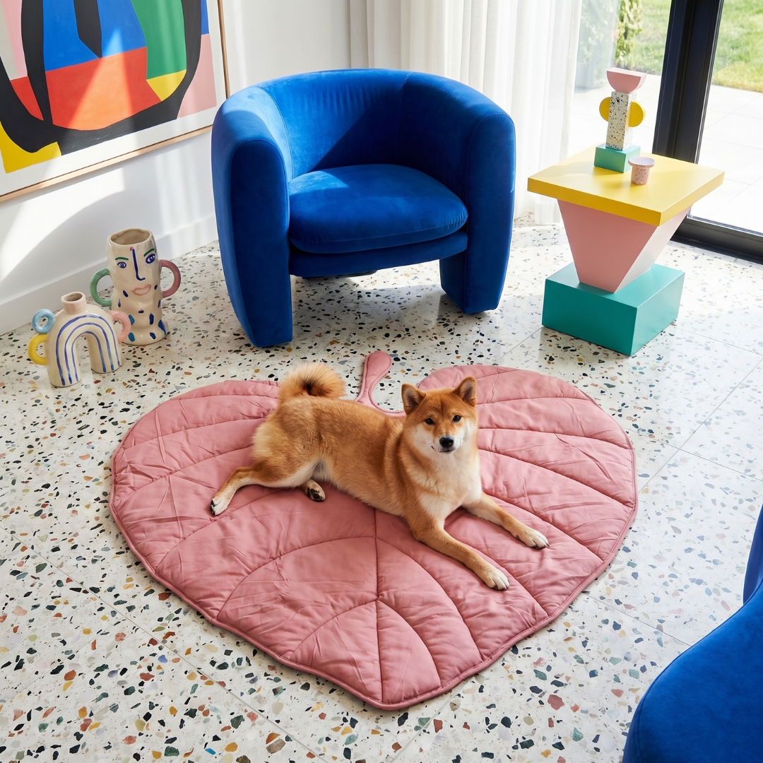 Shiba Inu dog relaxing on a pink, leaf-shaped Cloud Leaf Calming Dog Bed Mat in a modern living room.